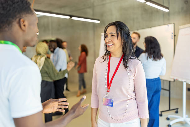 istock Two diverse business professionals exchanging ideas during meet and greet gathering at seminar 2203423948