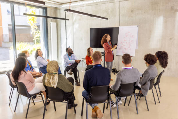 istock Businesswoman presenting new ideas to diverse audience with flipchart 2203424018