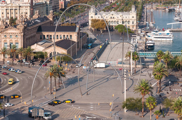 Barcelona, Spain - November 4, 2014: Aerial view of Plaza de les Glories, arches, and port under clear skies at sunset.