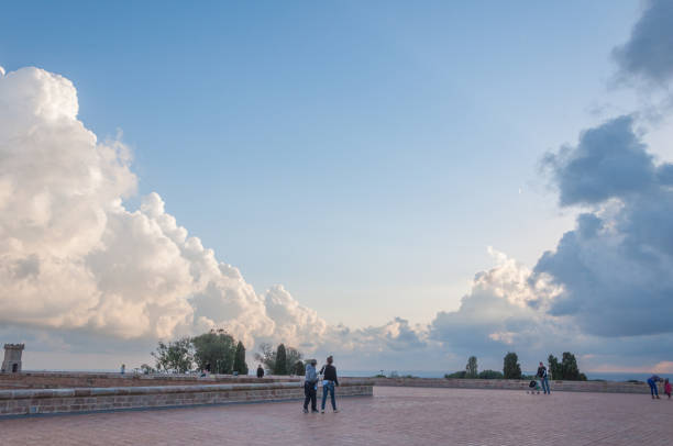 Barcelona, Spain - November 4, 2014: Visitors enjoying a serene evening at Montjuic Castle with a backdrop of dramatic clouds and a clear sky.
