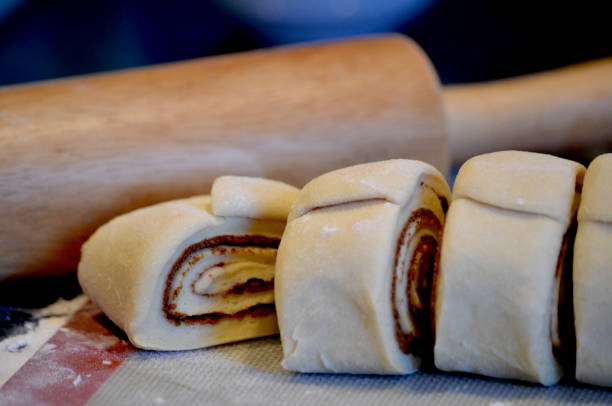 istock Close up of Cinnamon Roll freshly cut with rolling pin in background 2203428696