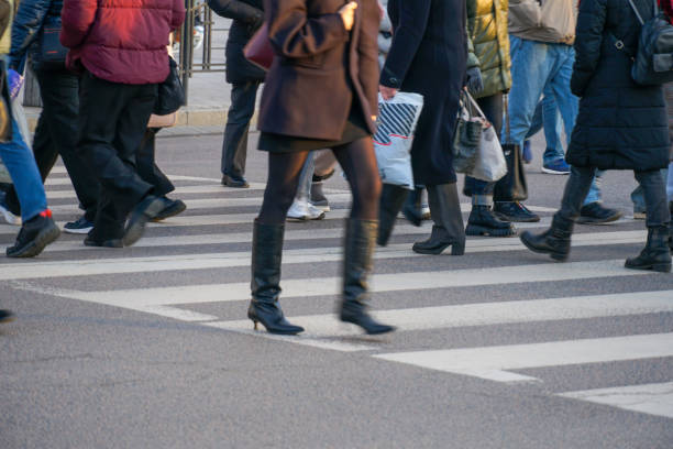 istock Crowds navigate a busy crosswalk in an urban setting as winter light casts long shadows in the late afternoon hours. Diverse outfits reflect seasonal fashion 2203428744
