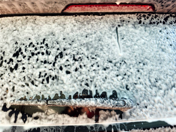 Detergent car wash, foam background car window detail.