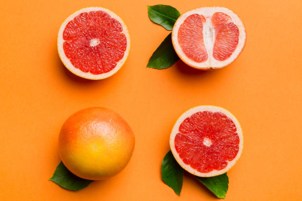 istock fresh Fruit grapefruit with Juicy grapefruit slices on colored background. Top view. Copy Space. creative summer concept. Half of citrus in minimal flat lay with copy space 2203432882