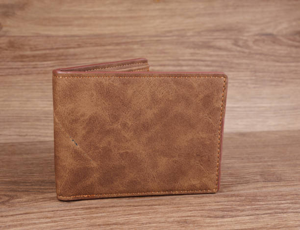 istock A beautiful leather wallet lies on a wooden surface. 2203433794