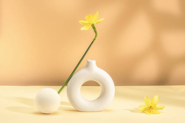 istock Stylish composition with yellow daffodil and ceramic vase. Bright spring background. Copy space. 2203433865