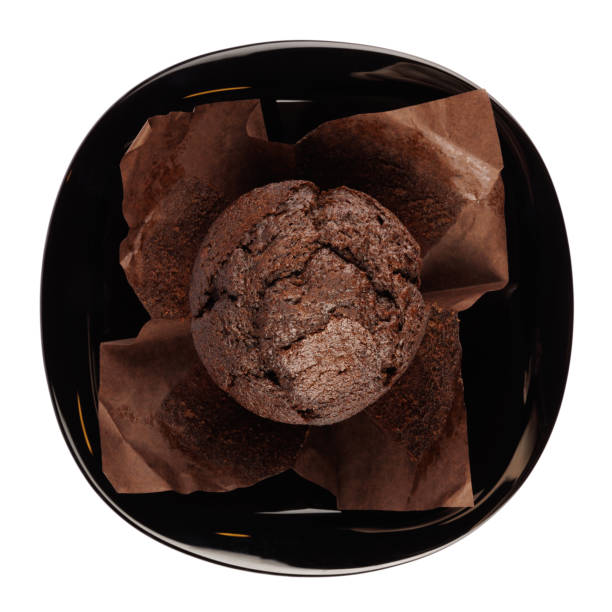 istock Chocolate muffin on black plate isolated on white background. 2203434192