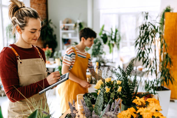 istock Engaged young florists collaborating in a vibrant flower shop while creating beautiful arrangements and enhancing their business 2203435847