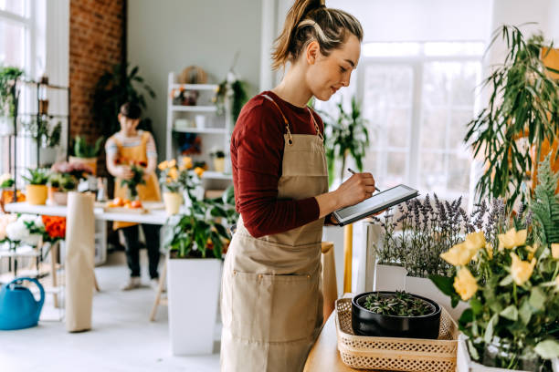 istock Young florist managing a vibrant flower shop, showcasing creativity and teamwork while arranging beautiful floral displays 2203439205