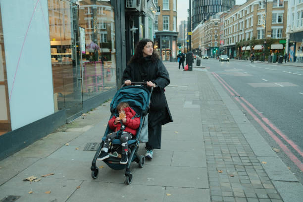 istock Mother pushing stroller with toddler on London sidewalk 2203440098