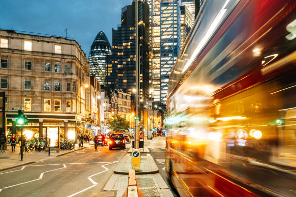 istock Red double-decker bus speeding through illuminated London streets at dusk 2203440149
