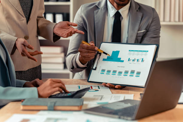 istock Business alliance groups by analyzing documents, discussing reports at the board meeting table. A multi-ethnic team is negotiating a project to develop a business strategy. Close-up image. 2203440886