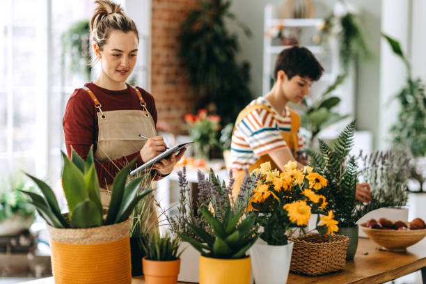 istock Young florists collaborating in a vibrant flower shop while creating beautiful arrangements and enhancing their small business 2203441677