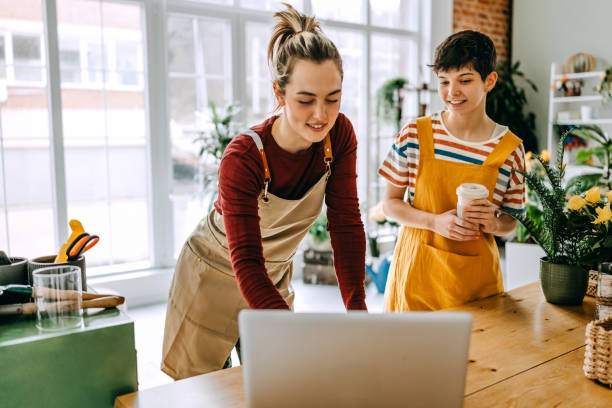 istock Young florists collaborating in a vibrant flower shop, sharing ideas and creating beautiful arrangements 2203441825