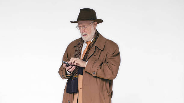 istock An elderly man in a hat talking on the phone on white background. He's laughing 2203442774
