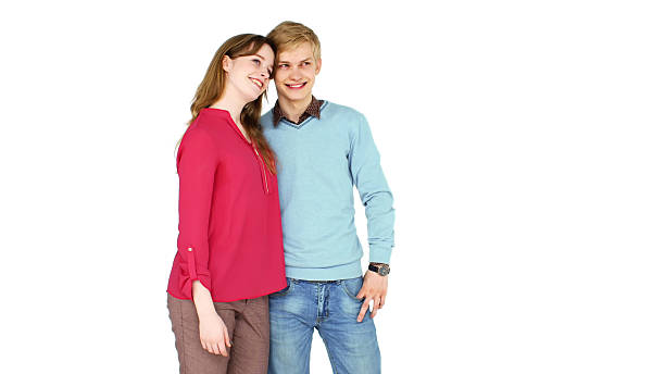 istock Young happy couple hugging and smiling while looking aside isolated over white background 2203442917