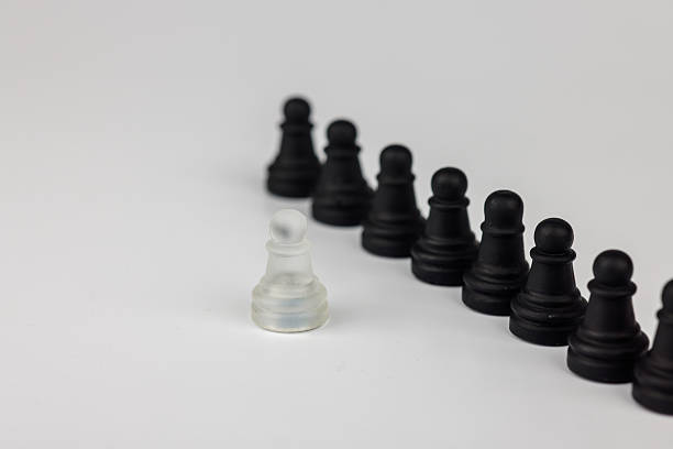 istock A thought-provoking chess setup where a single white pawn confronts black pawns. A toppled king represents the consequences of strategic choices 2203443121