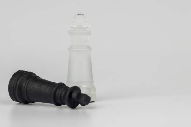 Elegant crystal chess kings, one toppled over, depicting the fine balance between victory and loss in a game of tactics and intelligence