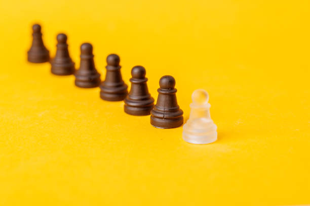 A group of wooden chess pieces with one of them being a king. The king is on top of the other pieces