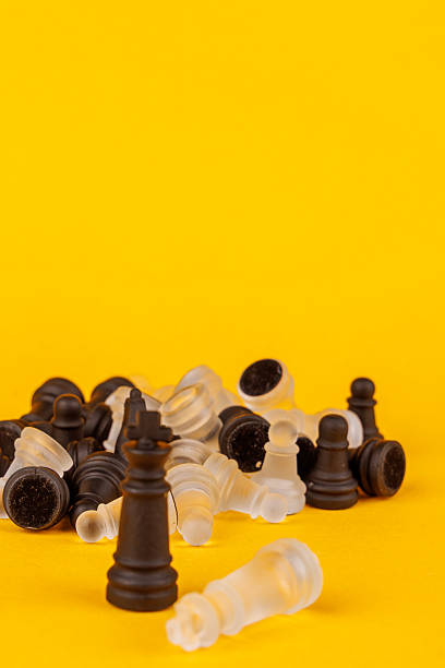 istock Chessboard scene shows black king victorious over white king, emphasizing strategy and competition. Fallen pieces enhance drama 2203444194