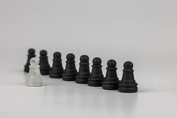 istock A powerful chess composition showing a white pawn against black pawns. A defeated king in the background represents resilience and strategic thinking 2203444298