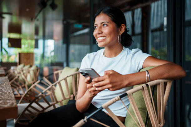 Smiling Woman Using Smartphone in Modern Caf