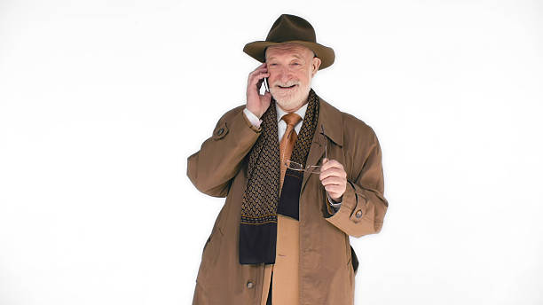 istock Elderly man in hat talking on cellphone isolated on white background. 2203444858
