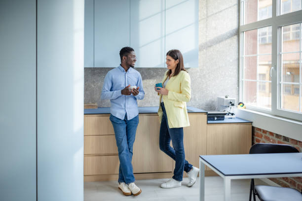 istock Young professionals engage in conversation while enjoying a coffee break in a modern office setting 2203447236