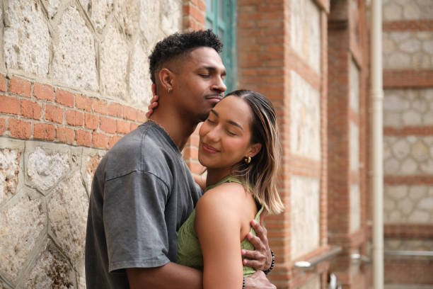istock Young couple hugging and showing affection in urban setting 2203448282