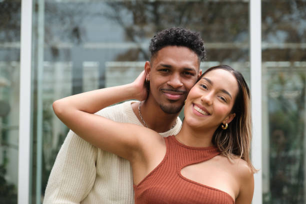 istock Young couple embracing and smiling at camera 2203449012