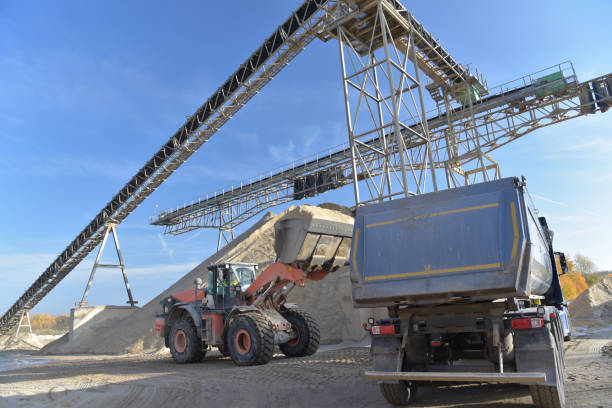 istock Gravel pit: building and wheel loader loading gravel onto a truck 2203449395