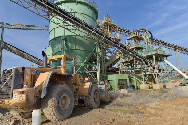 istock Gravel pit: building and wheel loader loading gravel onto a truck 2203449417