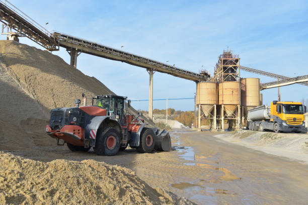 istock Gravel pit: building and wheel loader loading gravel onto a truck 2203449494