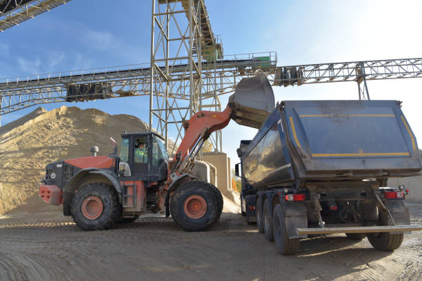 istock Gravel pit: building and wheel loader loading gravel onto a truck 2203449620