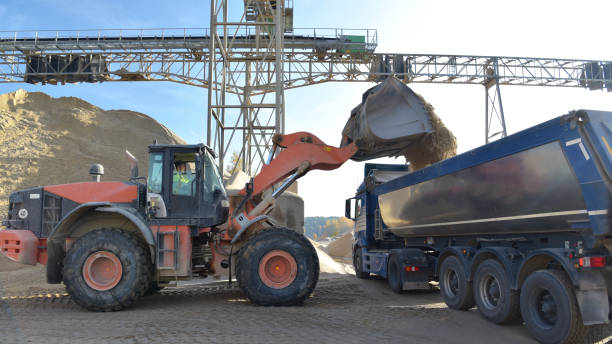 istock Gravel pit: building and wheel loader loading gravel onto a truck 2203449753