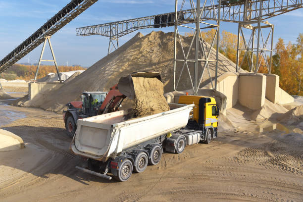 istock Gravel pit: building and wheel loader loading gravel onto a truck 2203449810