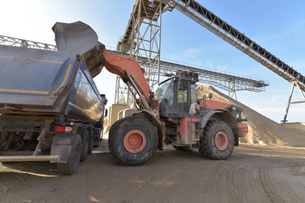 istock Gravel pit: building and wheel loader loading gravel onto a truck 2203449857