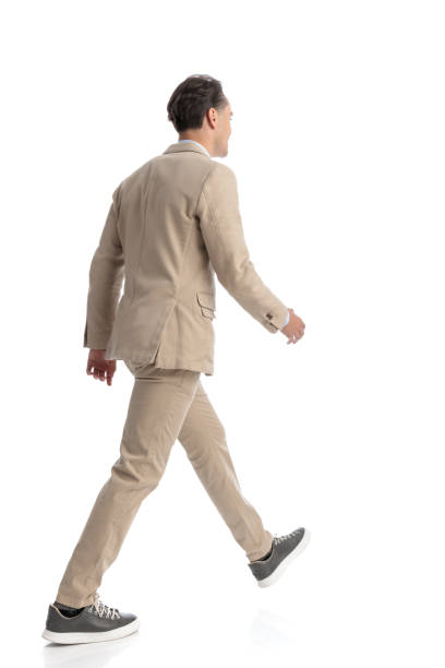 istock back view of young student in beige suit stepping 2203452663