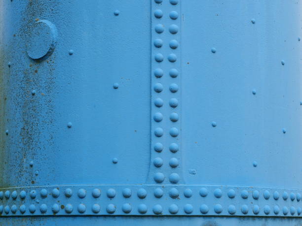 istock Light blue riveted metal wall of a tank 2203454841