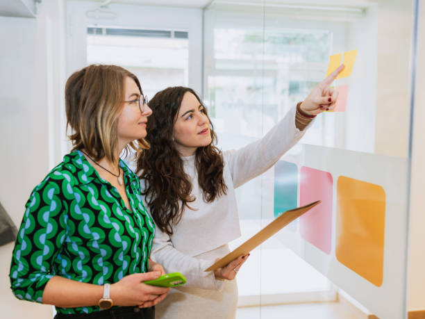 istock Businesswomen Brainstorming with Sticky Notes in Office 2203456678