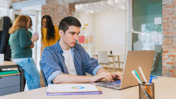 istock Focused Young Professional Working on Laptop in Modern Office 2203456694