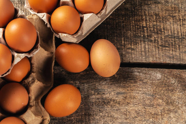 istock Chicken eggs in box on wooden table. 2203457295