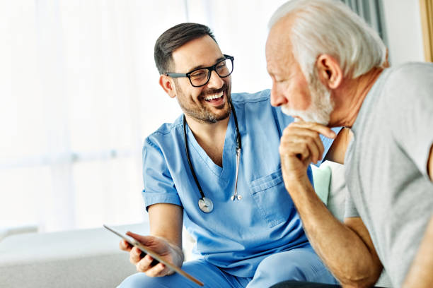 istock nurse doctor senior care tablet computer technology showing caregiver help assistence retirement home nursing elderly woman african american black happy laughing man 2203457320