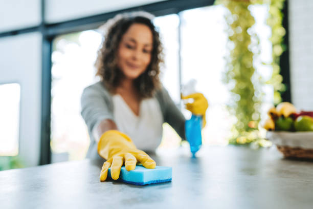istock A woman cleans the kitchen counter 2203460622