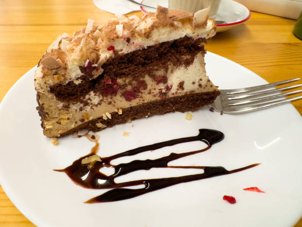 Chocolate raspberry layer cake slice with creamy filling on a plate.