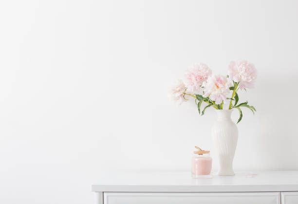 istock pink peonies in ceramic white vase in white interior 2203461429