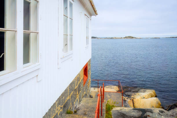 istock White wooden wall and seascape on background. Norway 2203461990
