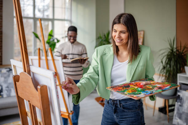 istock Young artists explore creativity together in a vibrant art studio during a collaborative painting session 2203462116