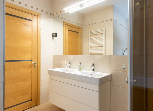 istock Modern Bathroom Interior with Wooden Door and Double Vanity 2203462537