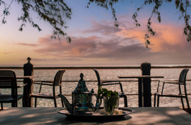 istock teapot and cup of Moroccan tea facing the sea. 2203462701
